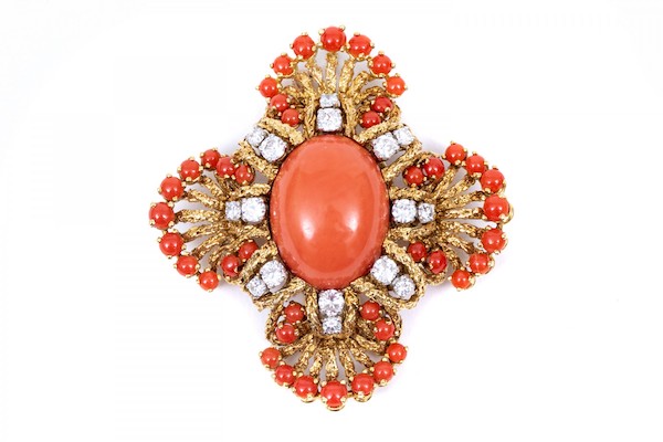 18K yellow gold, diamond and coral brooch. The scalloped edges of this brooch frame a pale red coral piece while small coral pieces trim the edges. Radiating out from the center are round brilliant cut diamonds and coral. The diamonds are approximately 1.64 TCW.